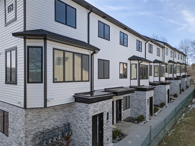 view of front facade featuring a sunroom, stone siding, and exterior kitchen