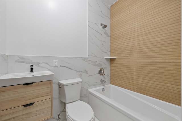 bathroom featuring bathtub / shower combination, vanity, toilet, and tile walls