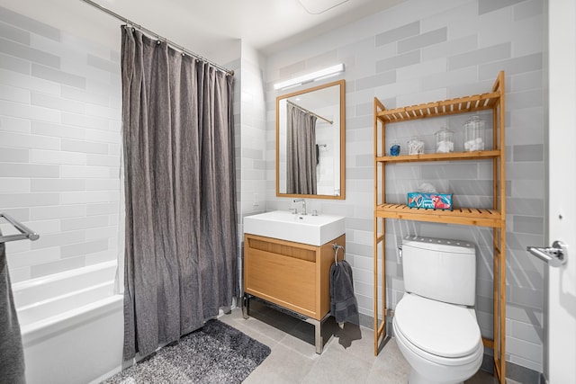 bathroom featuring tile walls, shower / bath combination with curtain, toilet, vanity, and tile patterned flooring