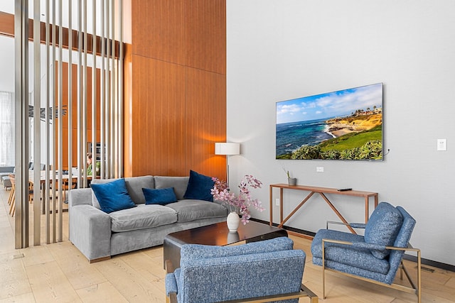 living area featuring a high ceiling and hardwood / wood-style floors