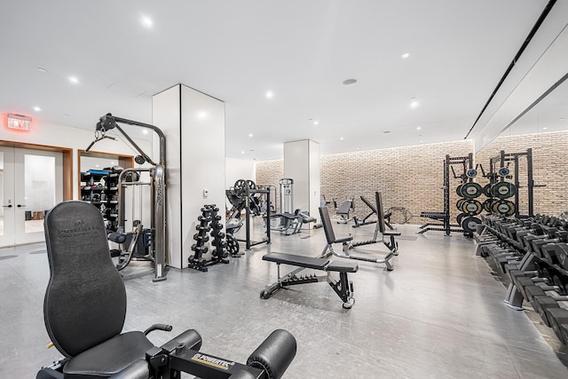 exercise room featuring recessed lighting, french doors, and brick wall