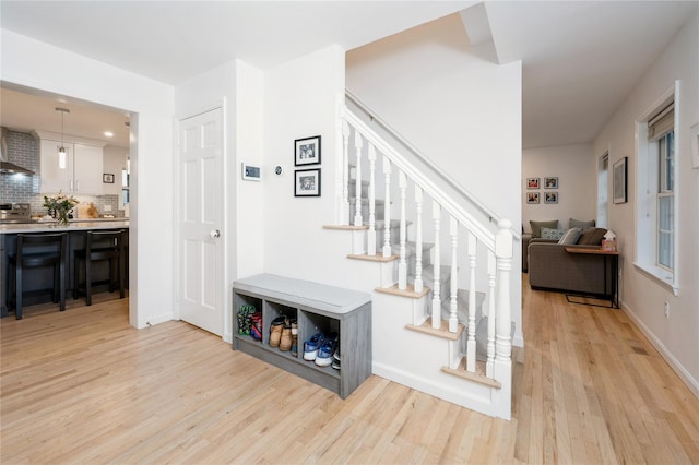 interior space featuring visible vents, light wood-style flooring, baseboards, and stairs