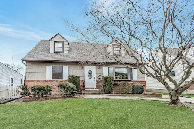 view of front of property featuring a front yard, fence, and brick siding