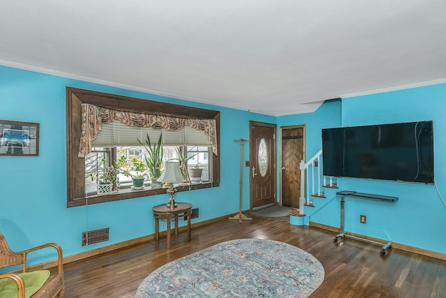 foyer with stairway, wood finished floors, and ornamental molding