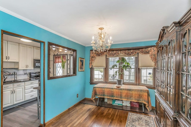 dining space featuring a notable chandelier, ornamental molding, wood finished floors, and baseboards