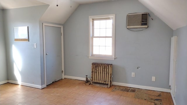 additional living space with lofted ceiling, radiator heating unit, baseboards, and a wall mounted AC