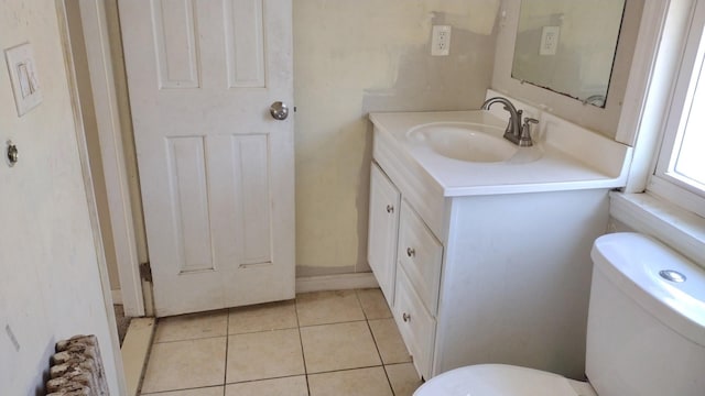 half bath featuring vanity, toilet, and tile patterned floors