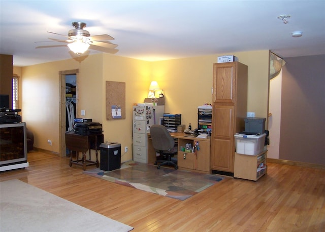 office space with baseboards, ceiling fan, and light wood-style floors