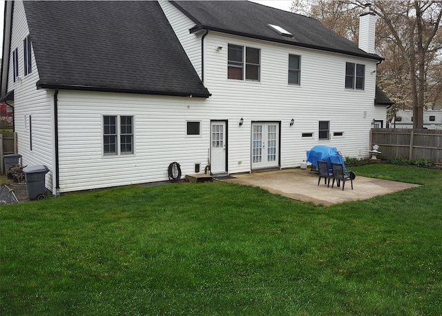 back of property with a yard, fence, french doors, and a patio