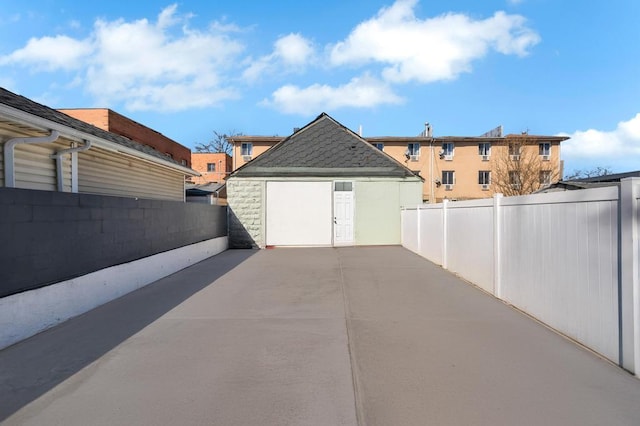view of patio / terrace with an outbuilding, a fenced backyard, and a detached garage