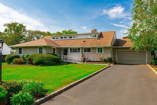 view of front of house featuring a garage, a front yard, and driveway