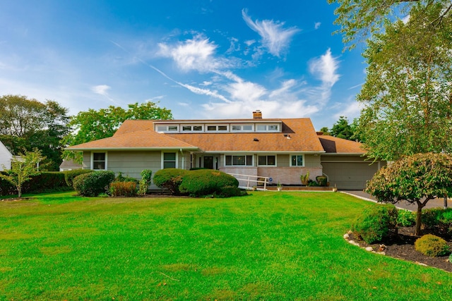 back of house featuring a yard and an attached garage