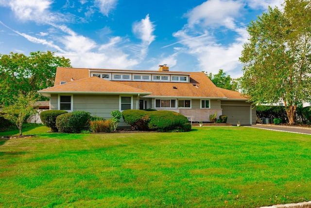 view of front of home featuring a garage, driveway, and a front yard