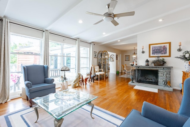 living room with vaulted ceiling with beams, ceiling fan, light wood finished floors, and a wealth of natural light