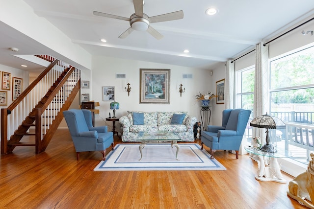 living room featuring lofted ceiling with beams, stairway, wood finished floors, and visible vents