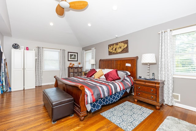 bedroom featuring multiple windows, vaulted ceiling, and wood finished floors