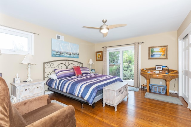 bedroom with a ceiling fan, visible vents, baseboards, and wood finished floors