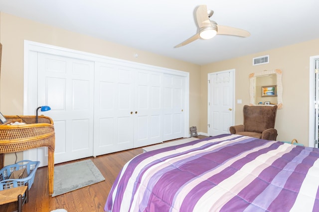 bedroom featuring ceiling fan, a closet, visible vents, and wood finished floors