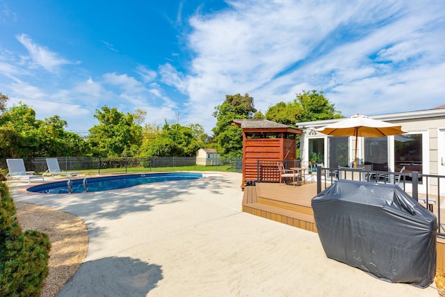 view of pool featuring a fenced in pool, a patio, grilling area, fence, and a deck