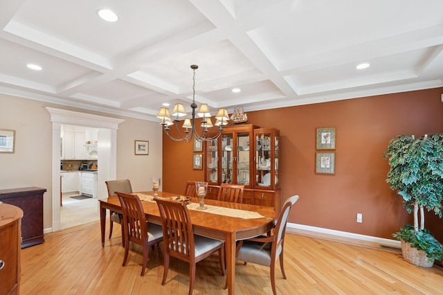 dining area with light wood-style floors, coffered ceiling, and baseboards