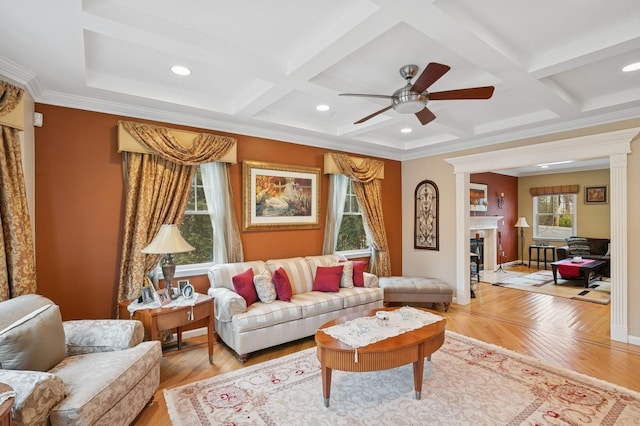 living room featuring light wood-style floors, a fireplace, and coffered ceiling