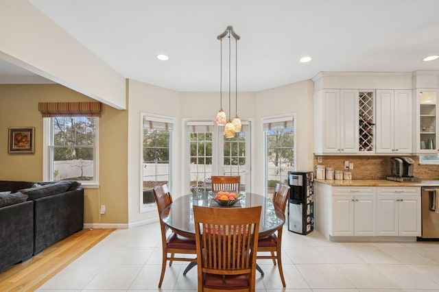 dining space with baseboards, a wealth of natural light, and recessed lighting