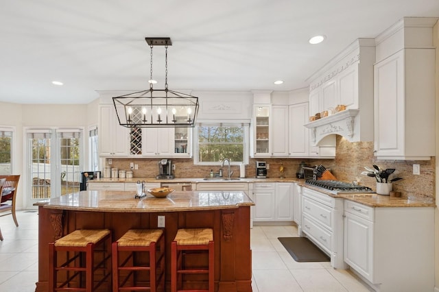 kitchen with a kitchen breakfast bar, a healthy amount of sunlight, a sink, and decorative backsplash