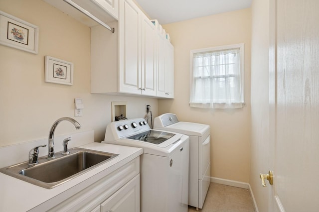 laundry area featuring baseboards, a sink, cabinet space, and washer and dryer