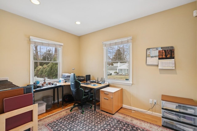 home office featuring recessed lighting, baseboards, a wealth of natural light, and wood finished floors