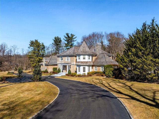 view of front of home with driveway and a front lawn