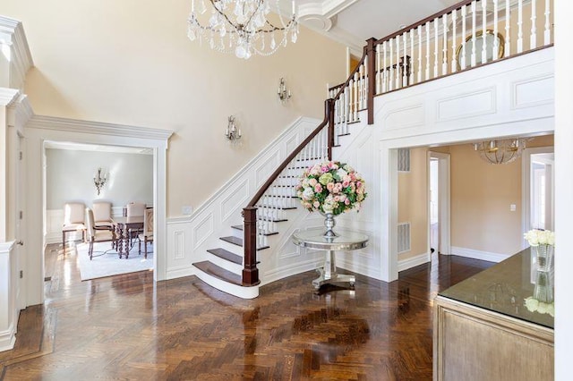 stairway featuring a chandelier, visible vents, and a towering ceiling