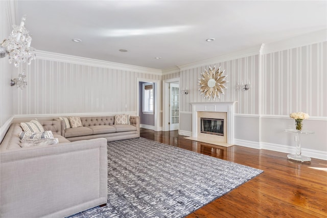 living area featuring a fireplace, baseboards, hardwood / wood-style floors, and ornamental molding