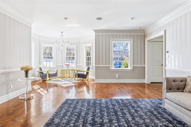 sitting room with a wealth of natural light, baseboards, crown molding, and hardwood / wood-style floors