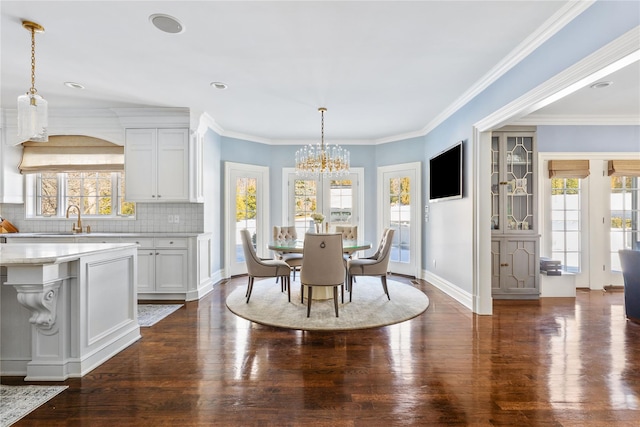 dining room featuring dark wood-type flooring, a wealth of natural light, a notable chandelier, and crown molding