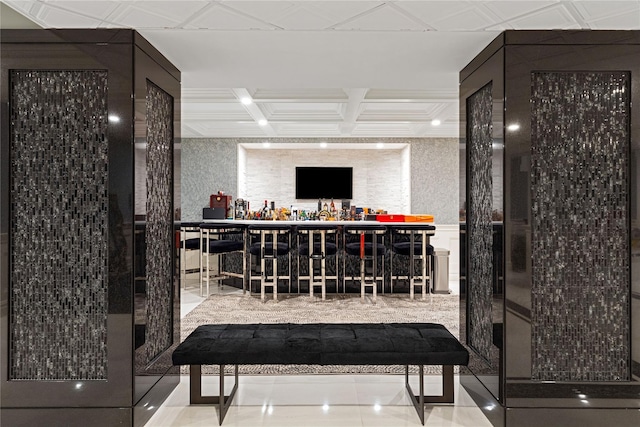 bar with a bar, coffered ceiling, and tile patterned floors