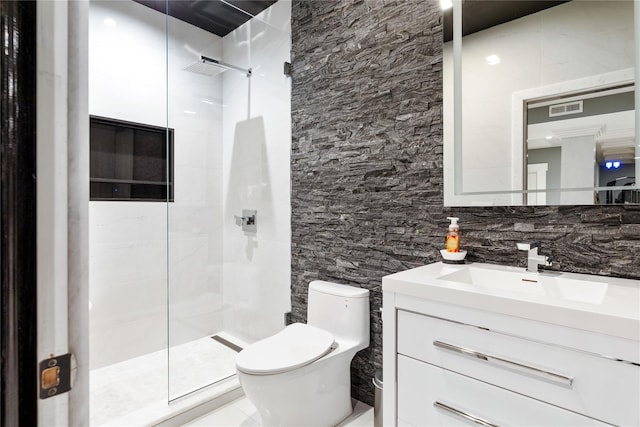 full bathroom with tiled shower, visible vents, toilet, and vanity