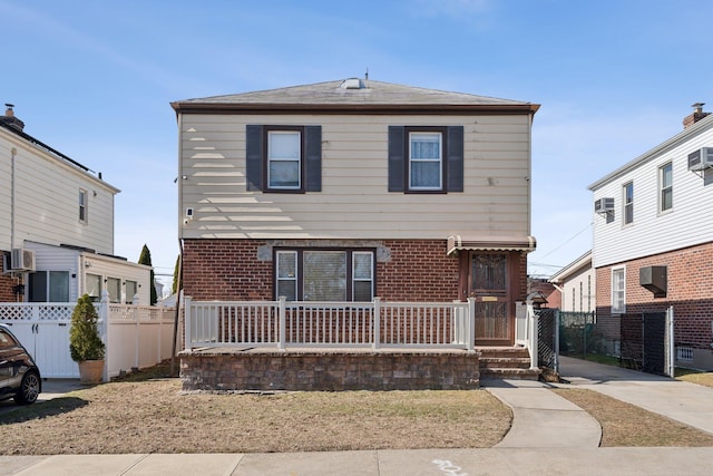 view of front of home with brick siding and fence