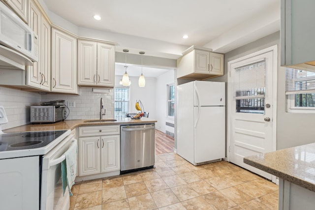 kitchen featuring backsplash, decorative light fixtures, recessed lighting, white appliances, and a sink