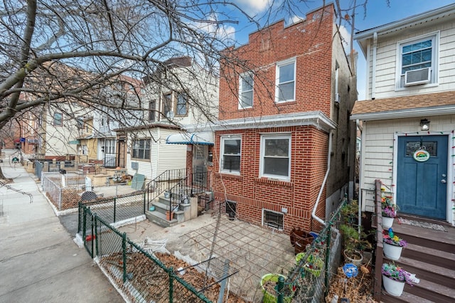 rear view of property with fence, cooling unit, and brick siding