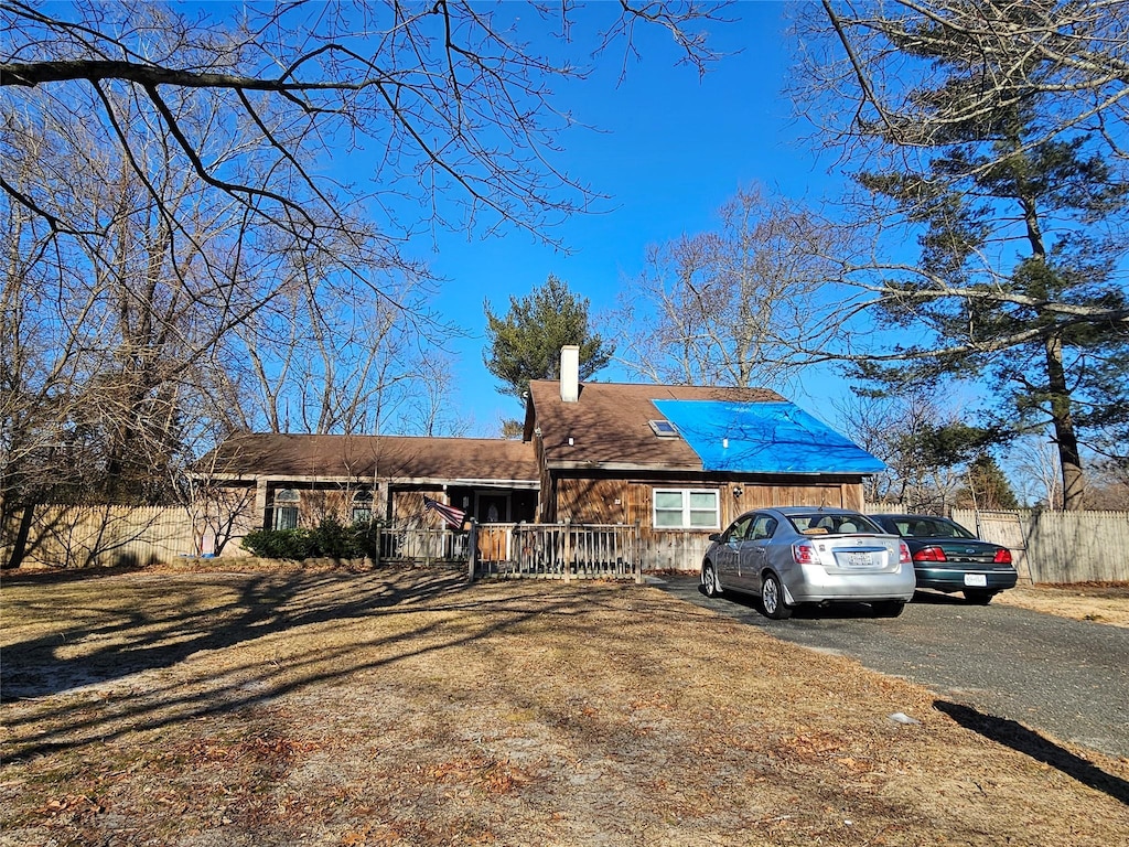 single story home with driveway and a chimney