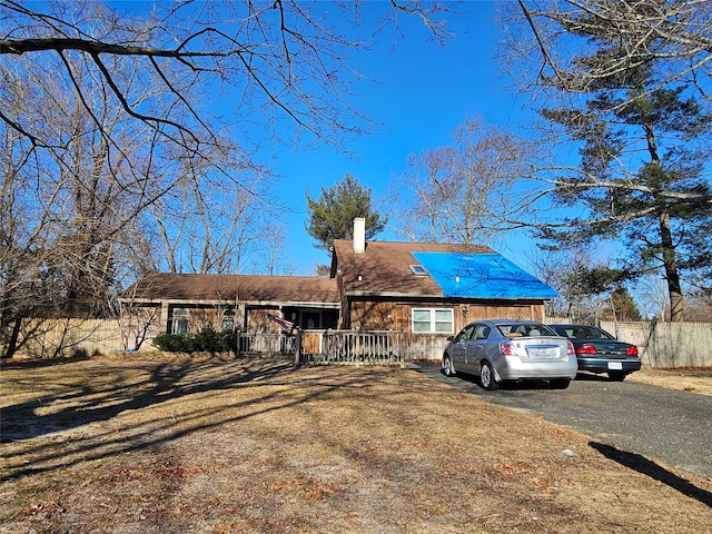 single story home with driveway and a chimney