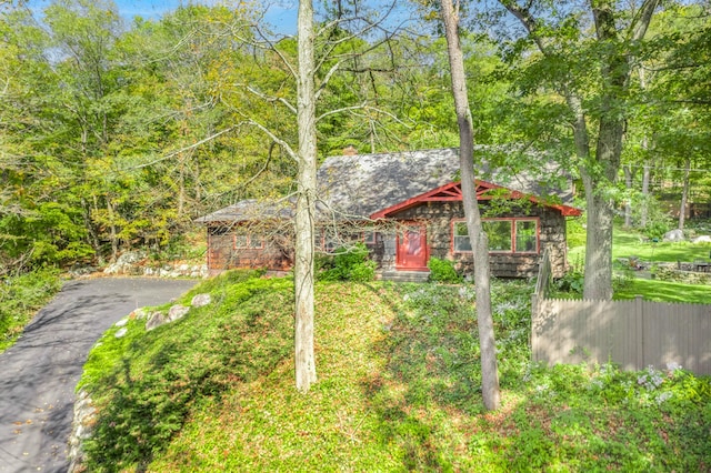 view of yard with aphalt driveway and fence