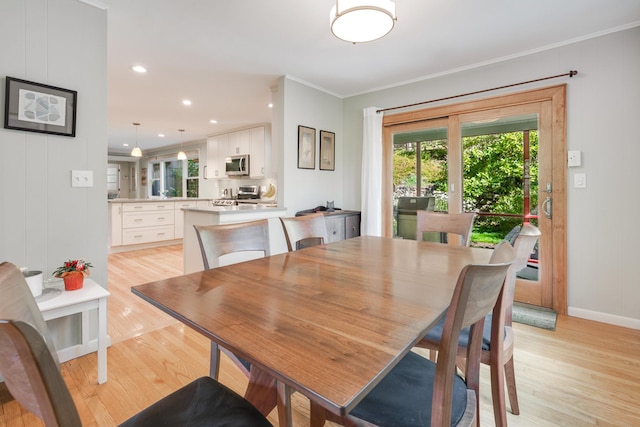 dining room with recessed lighting, crown molding, light wood-type flooring, and baseboards