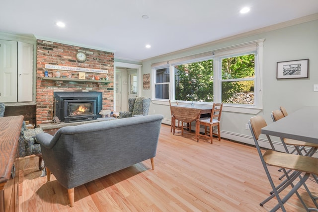 living room featuring baseboards, recessed lighting, ornamental molding, a brick fireplace, and light wood-type flooring