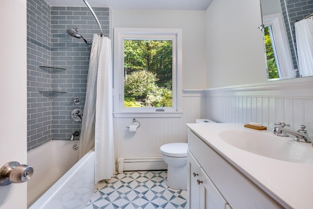 full bath featuring toilet, shower / bath combo, baseboard heating, wainscoting, and vanity