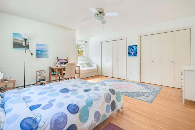 bedroom featuring two closets, light wood-type flooring, and a ceiling fan