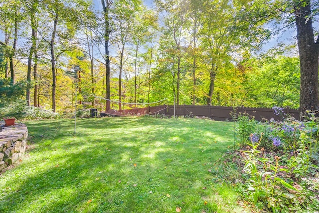 view of yard featuring fence and a forest view