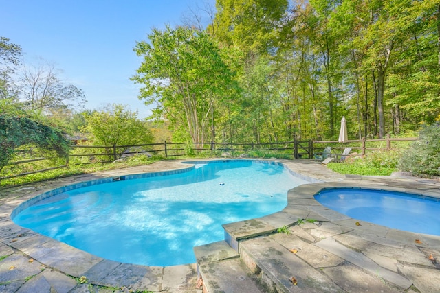 outdoor pool featuring a patio area, an in ground hot tub, and fence