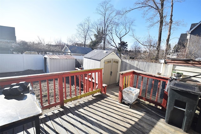 wooden deck with a storage shed, an outbuilding, and a fenced backyard