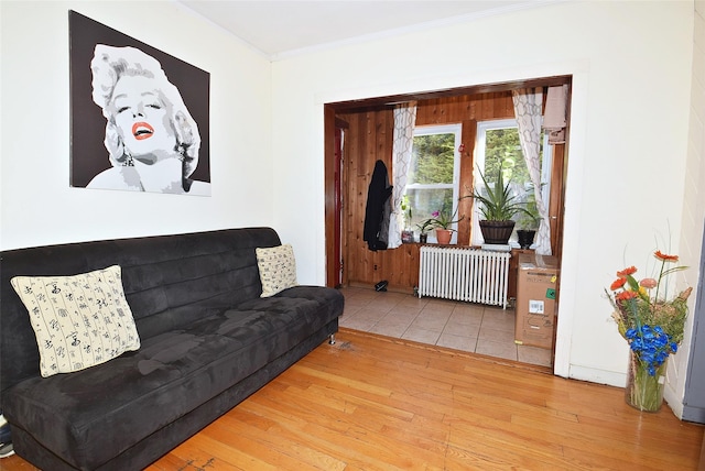 living room with radiator, crown molding, and wood finished floors